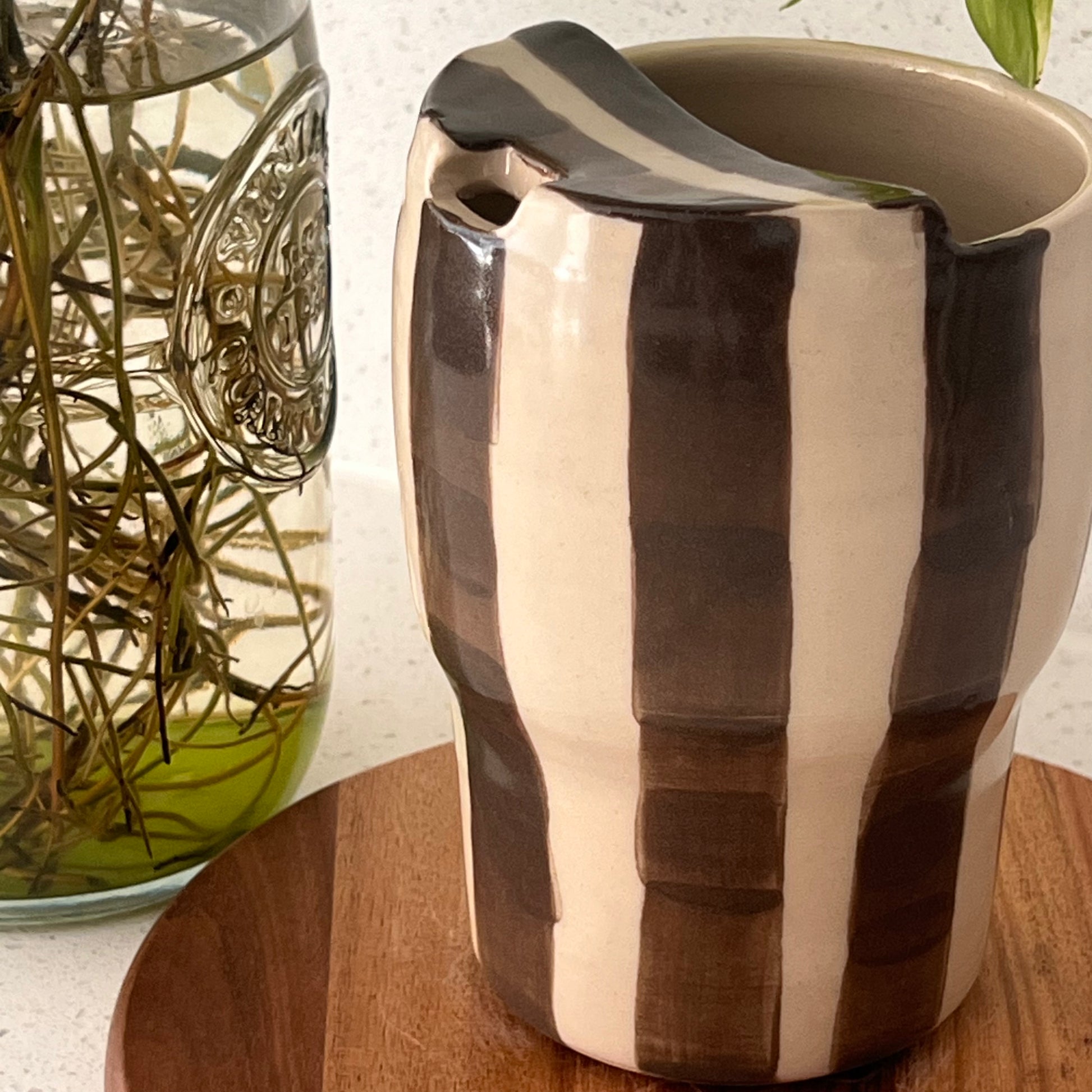 Ceramic cup with brown and beige stripes on a wooden surface